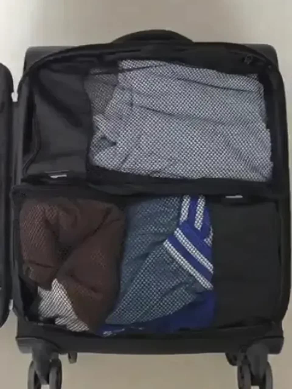 Cubes de rangement pour valise posés à côté d'une valise ouverte